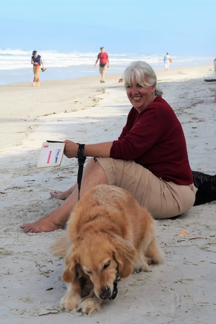 Honey the golden retriever and Pam wait on the beach at Fort Matanzas. | GoPetFriendly.com