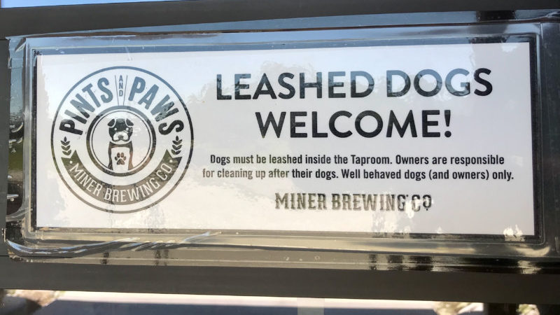 Leashed dogs welcome sign at pet friendly Miner Brewing Company in Hill City, SD