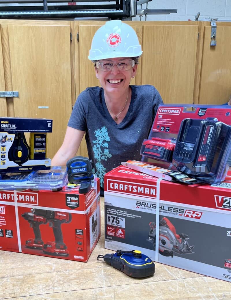 Woman in a hardhat with new tools used for construction